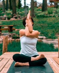 Woman performing yoga outdoors in a tropical setting