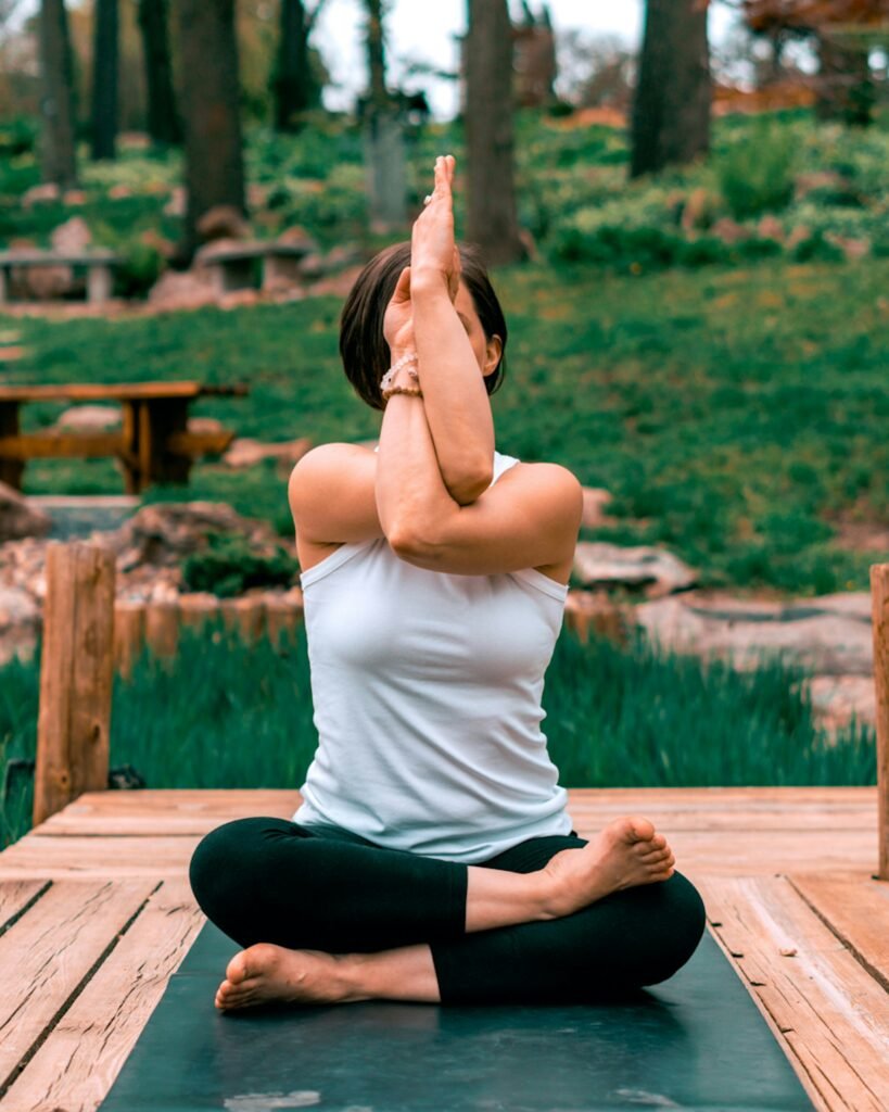 Woman performing yoga outdoors in a tropical setting