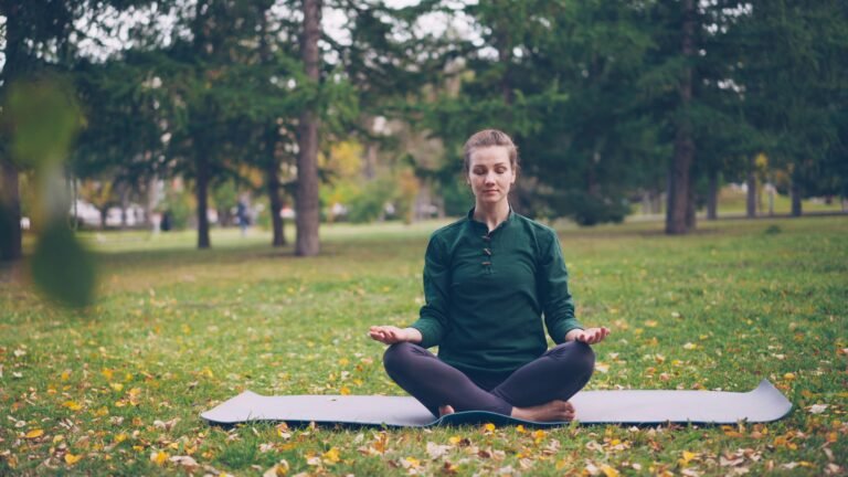 Woman meditating peacefully in an outdoor park setting